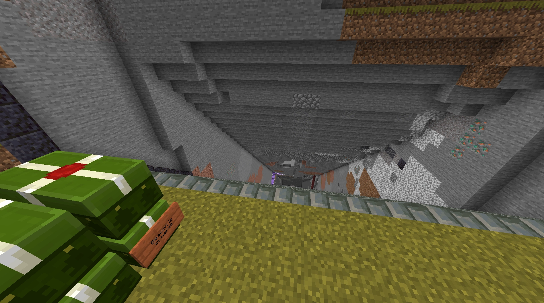 a staircase down to y -49 made of tuff brick

there is a chest monster near the top

one of the chests has a sign on it that indicates where the beacon has been stored