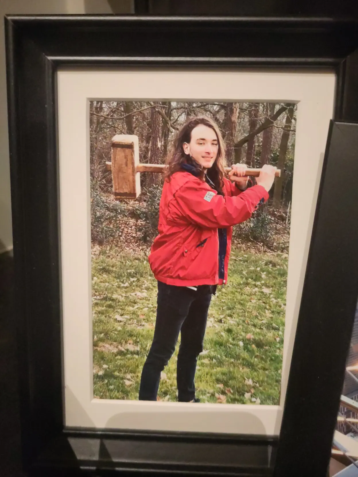 A framed picture of me standing in the woods with a very large wooden hammer.