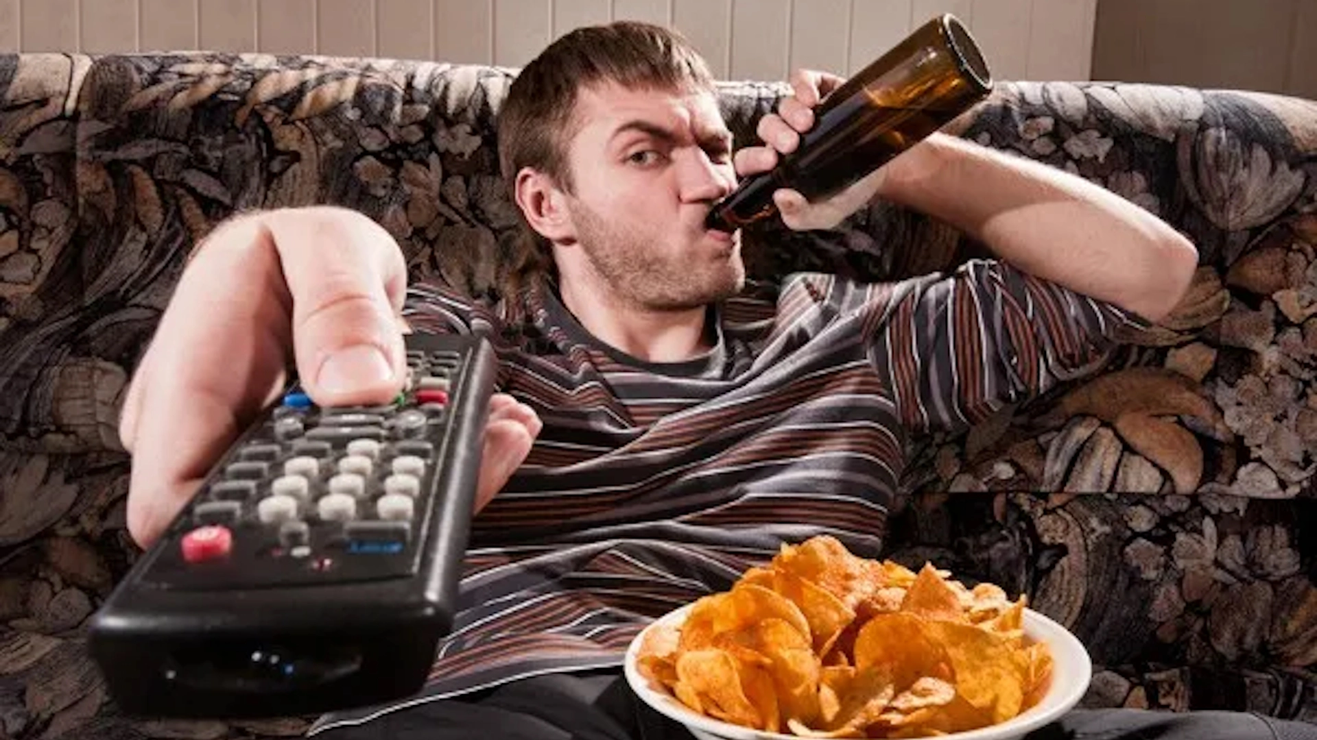 Dude one the couch drinking beer and holding a tv remote.

the composition is a fuck